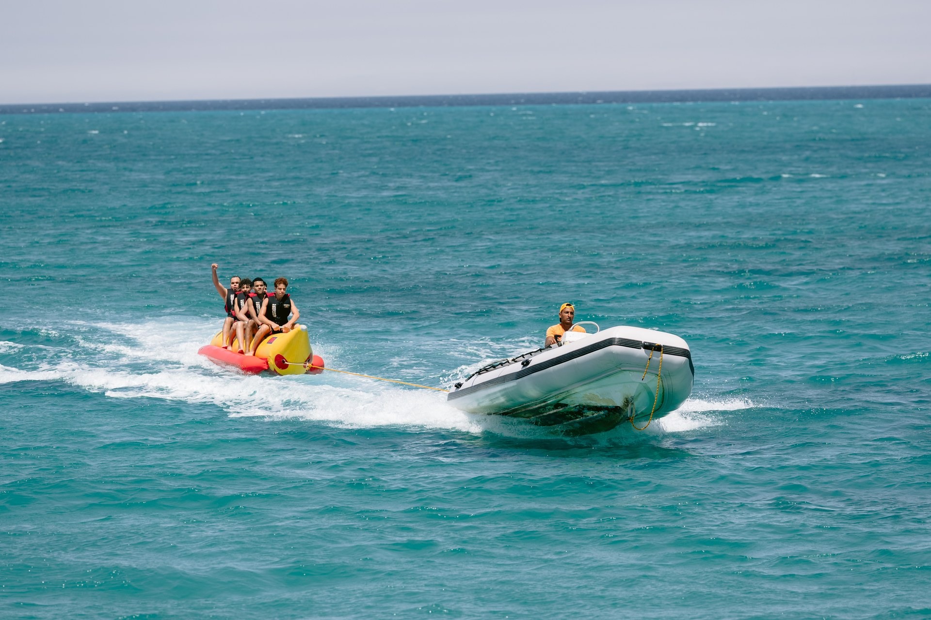 A banana boat and speedboat on the water during an event at BOHO Sokhna
